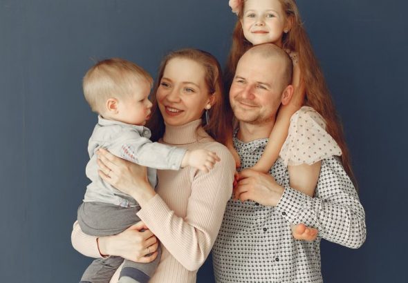 A joyful family portrait showcasing parents and their two children, expressing love and togetherness.