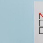 A minimalist checklist with a red checkmark on a blue background, providing ample copy space.