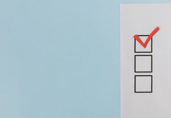 A minimalist checklist with a red checkmark on a blue background, providing ample copy space.