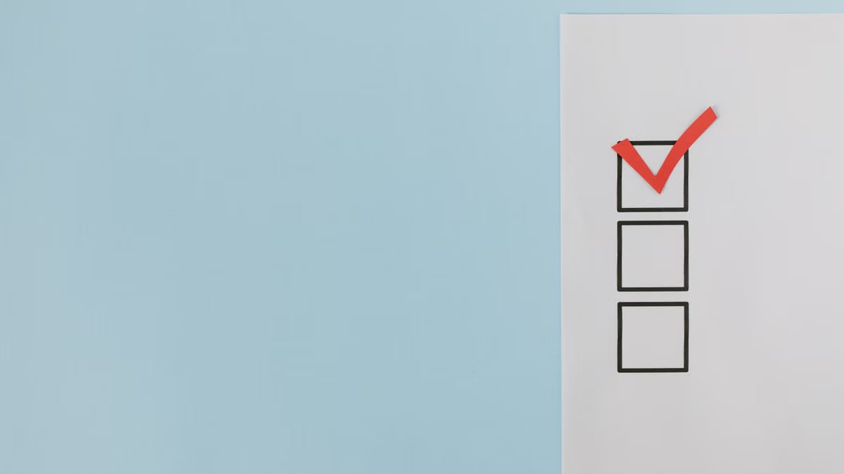 A minimalist checklist with a red checkmark on a blue background, providing ample copy space.